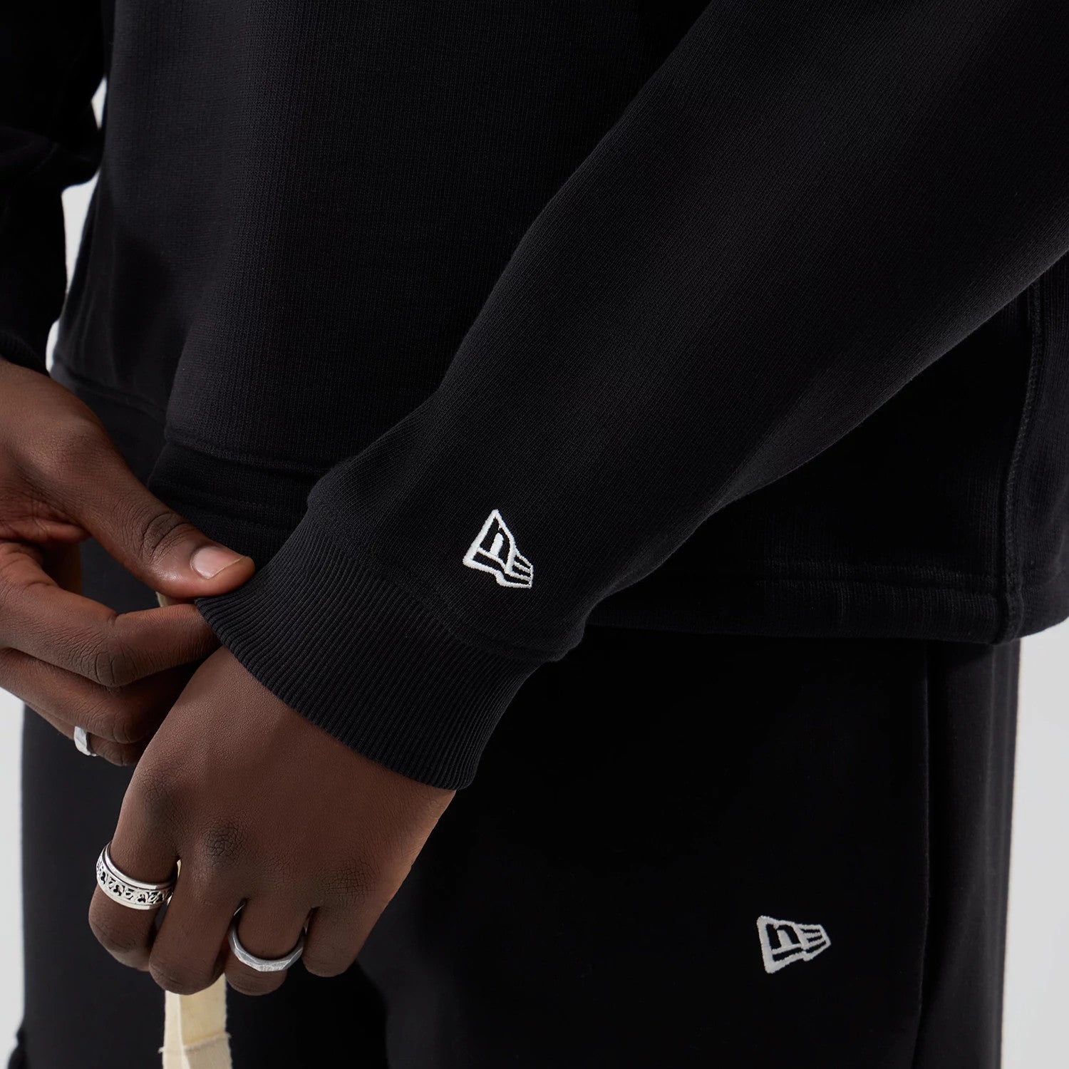 The model is wearing this New Era Oversized Crew Neck Sweater in black. 5