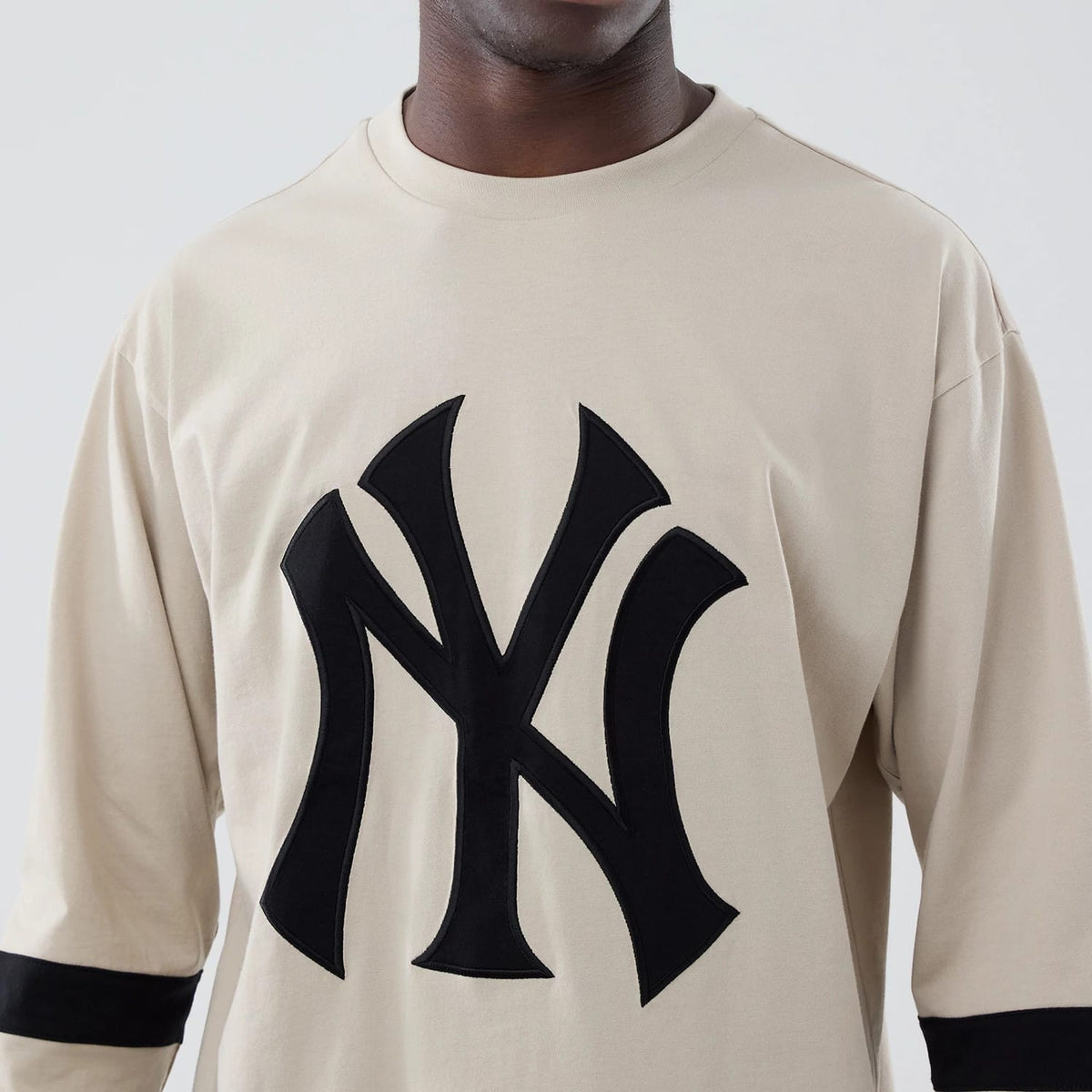 The model is wearing this MLB New York Yankees Oversized Long Sleeve T-Shirt in light beige. 4