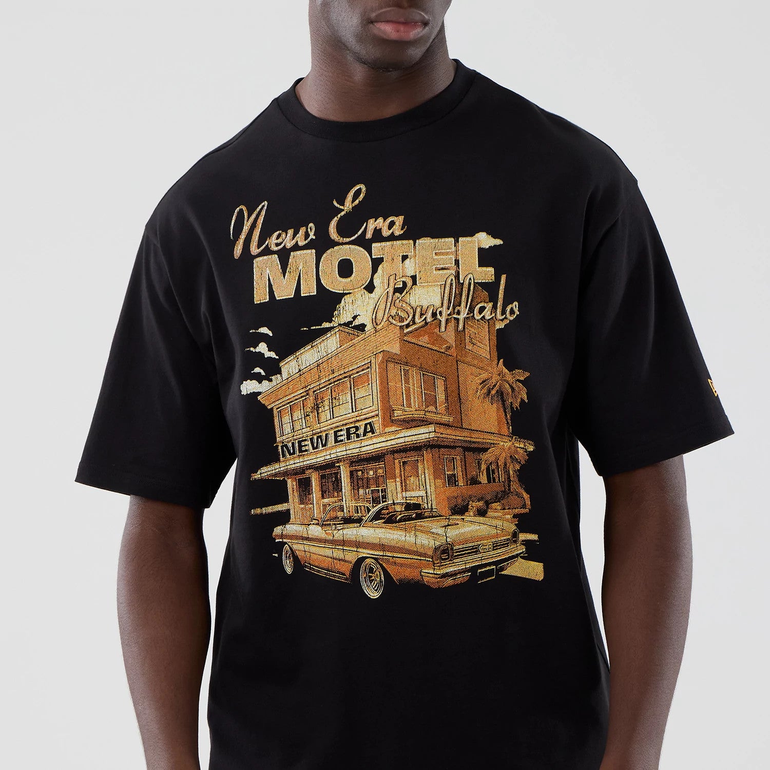 The model is wearing this New Era Motor Graphic Oversized T-Shirt in black. 3