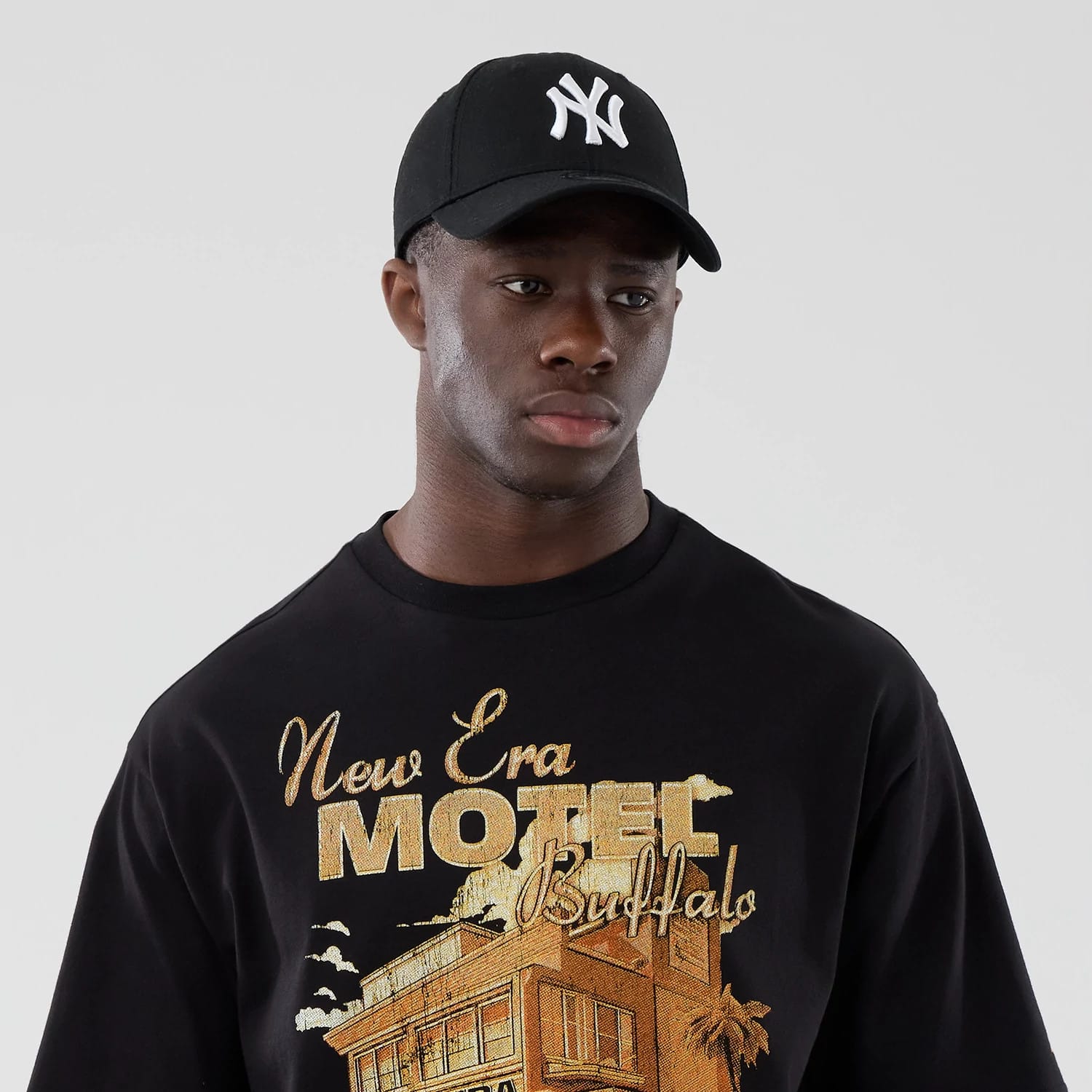 The model is wearing this New Era Motor Graphic Oversized T-Shirt in black. 6