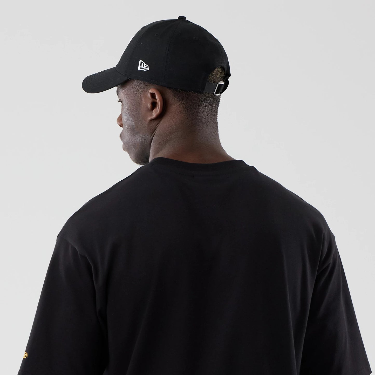 The model is wearing this New Era Motor Graphic Oversized T-Shirt in black. 7