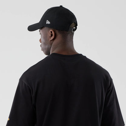 The model is wearing this New Era Motor Graphic Oversized T-Shirt in black. 7