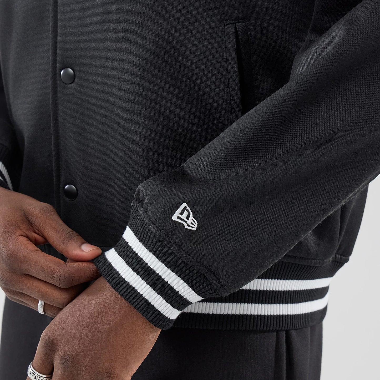 The model is wearing this New Era Jersey Bomber Jacket in black. 5