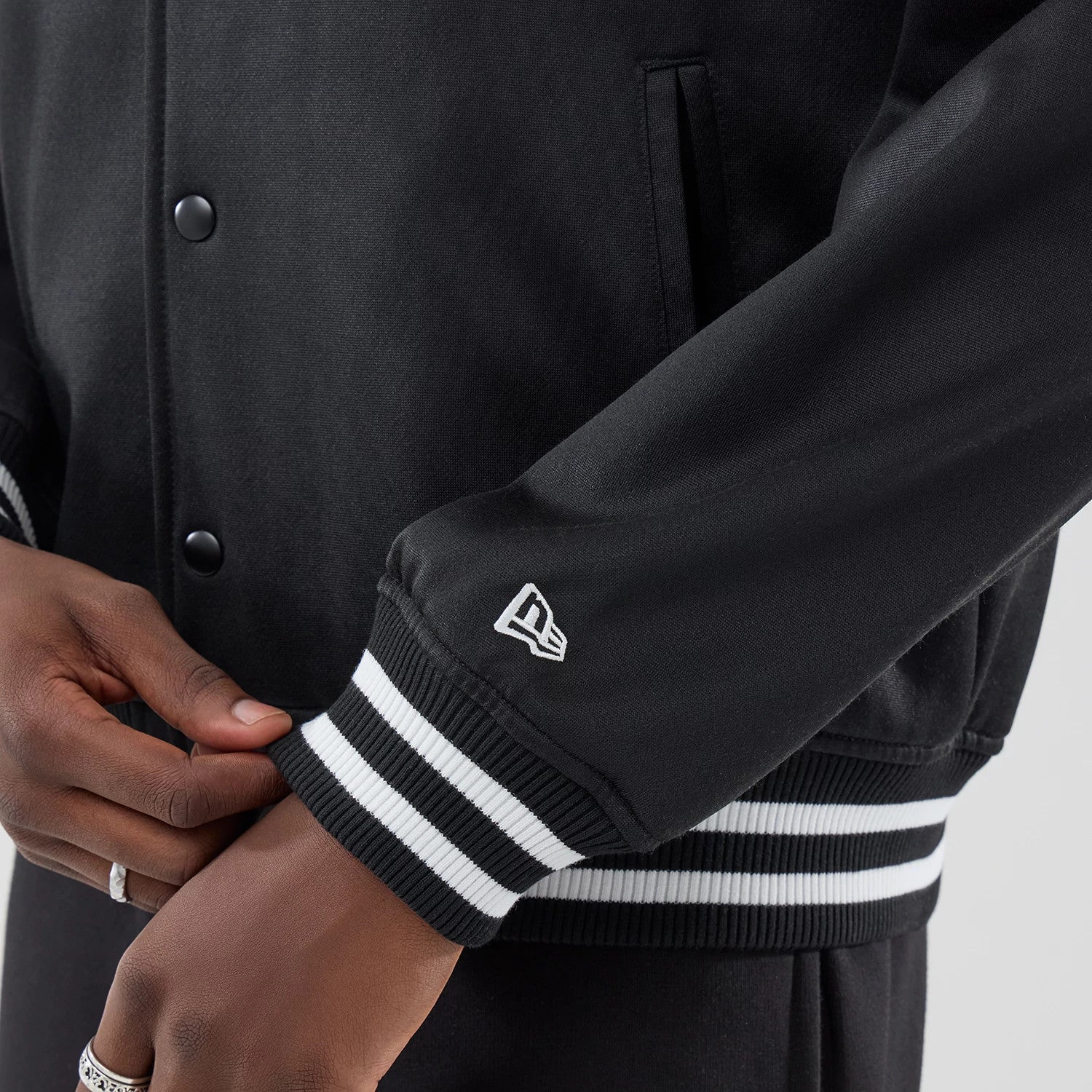 The model is wearing this New Era Jersey Bomber Jacket in black. 5