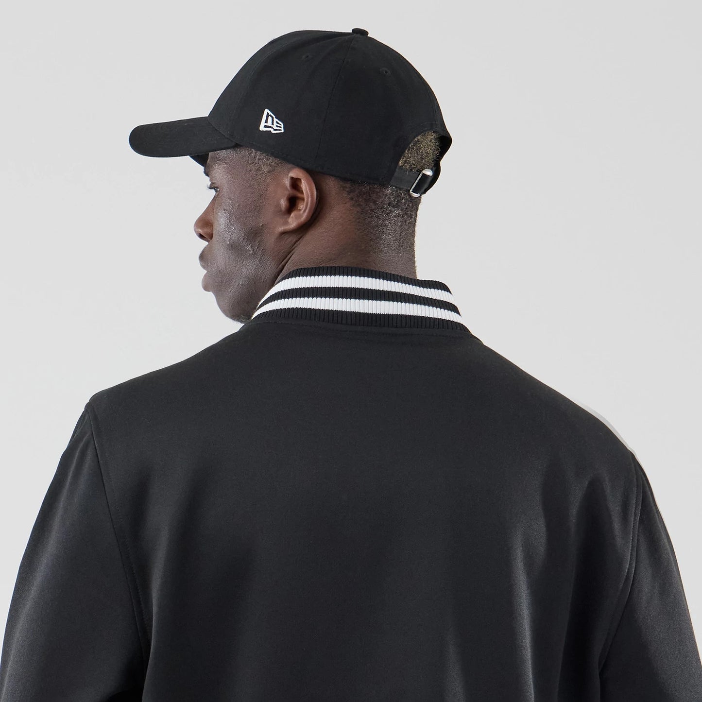 The model is wearing this New Era Jersey Bomber Jacket in black. 6