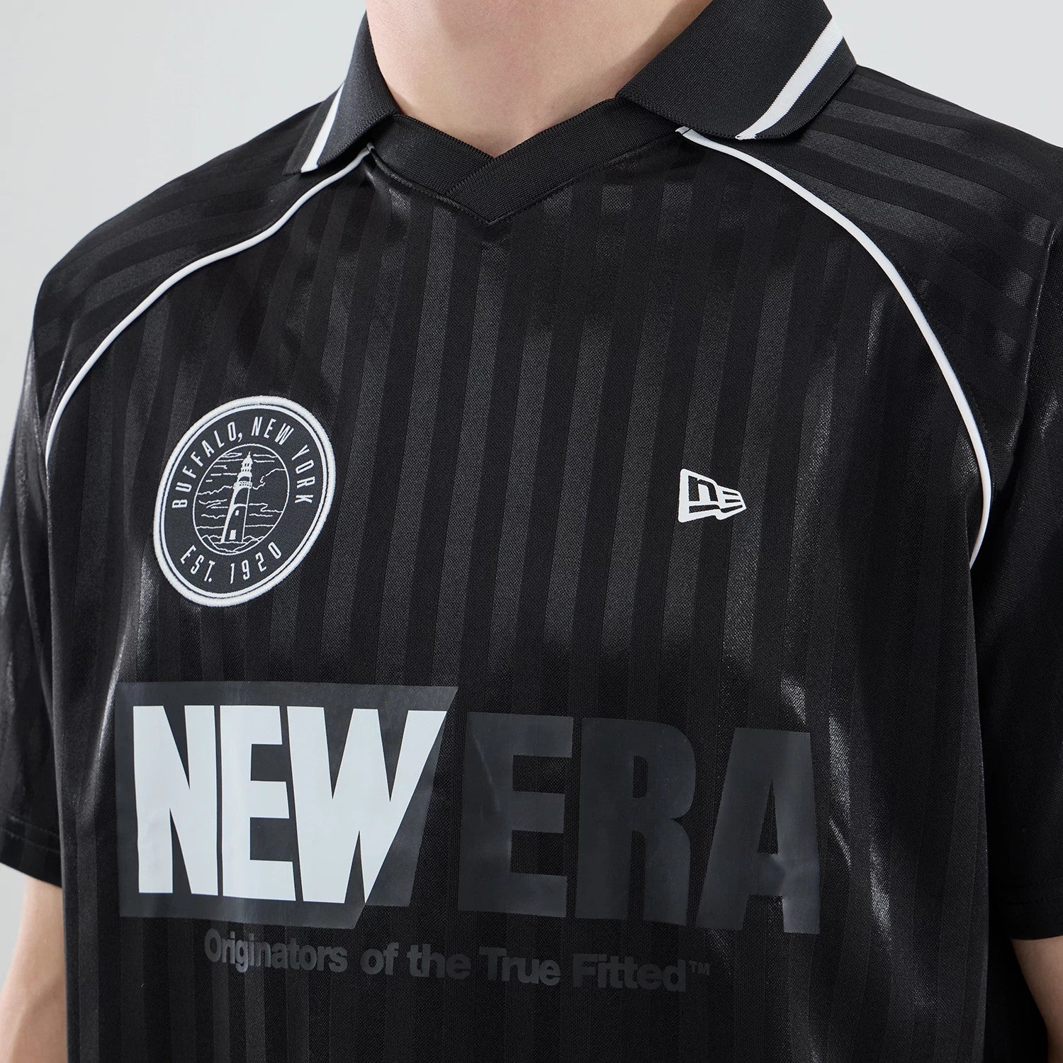 The model is wearing this New Era Football Jersey T-Shirt in black. 4
