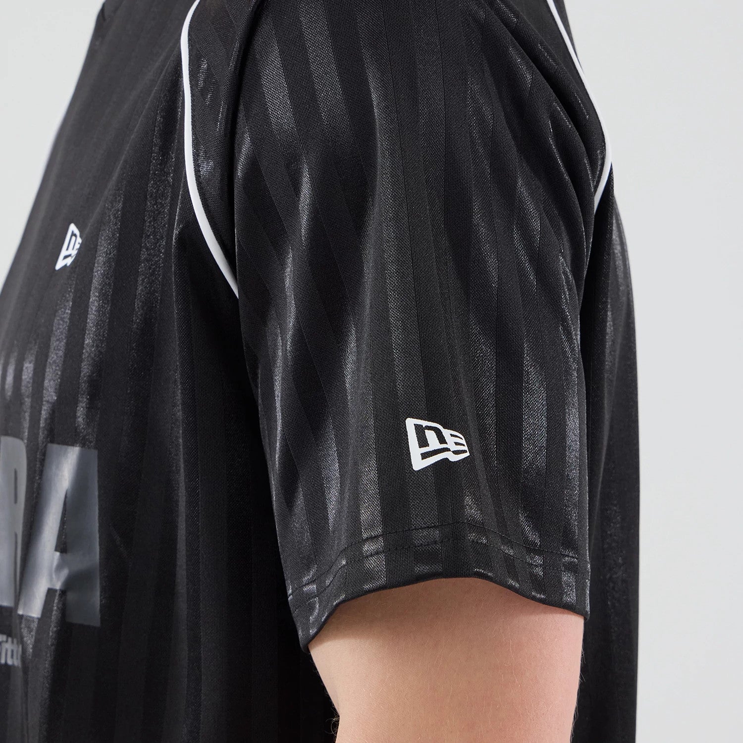 The model is wearing this New Era Football Jersey T-Shirt in black. 5