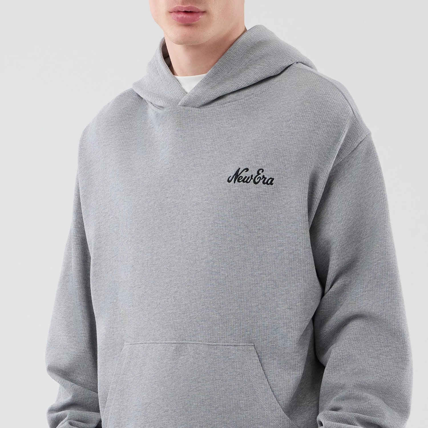 The model is wearing this New Era Open Hem Pullover Hoodie in grey. 3