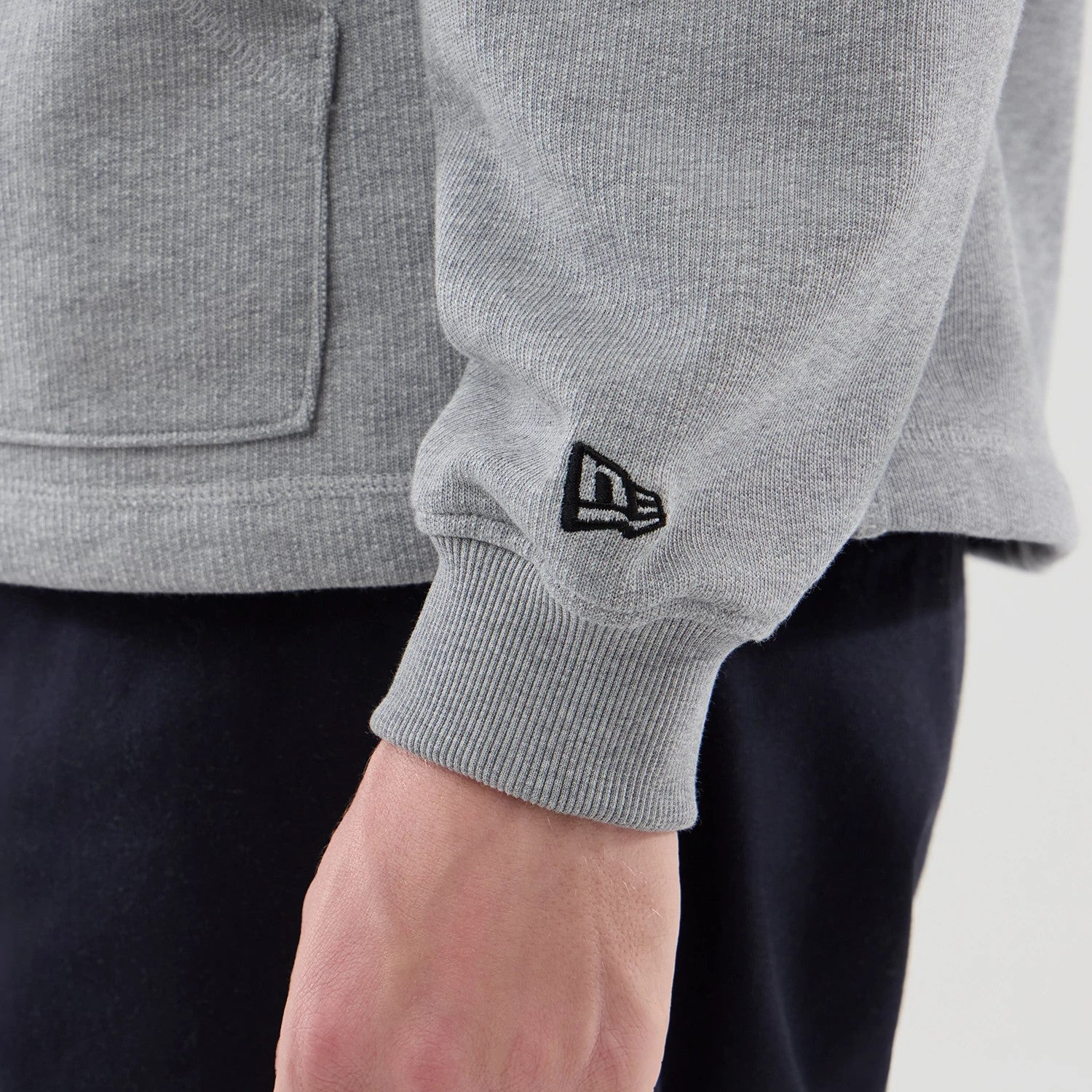 The model is wearing this New Era Open Hem Pullover Hoodie in grey. 5
