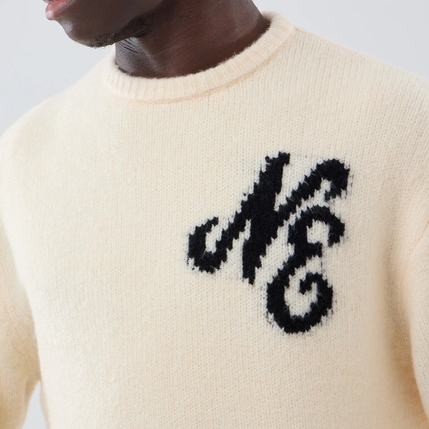 The model is wearing this New Era Knit Knitted Sweater in cream. 5