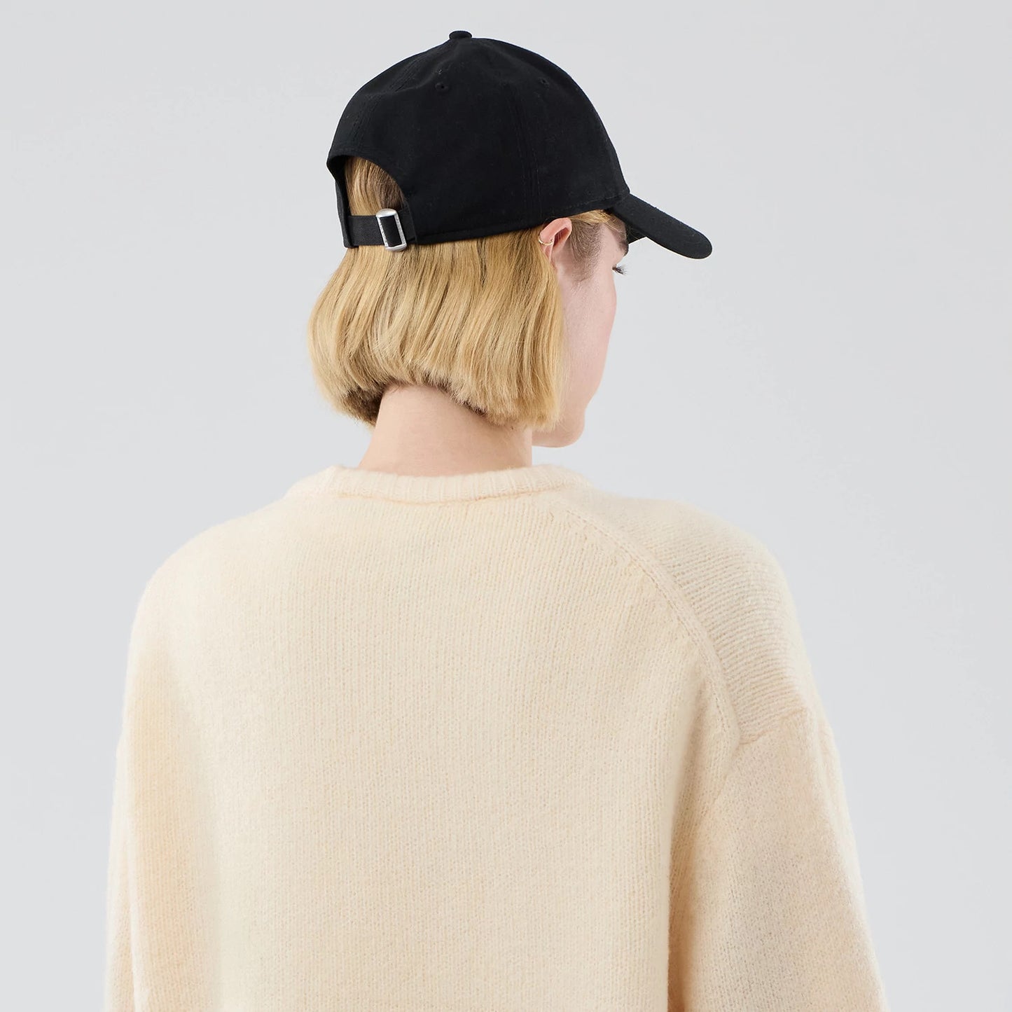 The model is wearing this New Era Knit Knitted Sweater in cream. 8