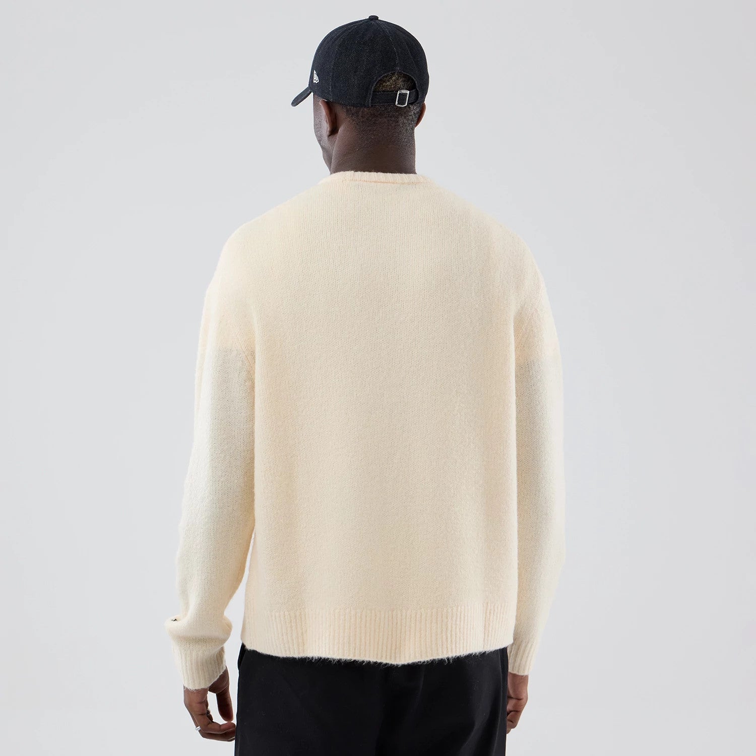 The model is wearing this New Era Knit Knitted Sweater in cream. 2