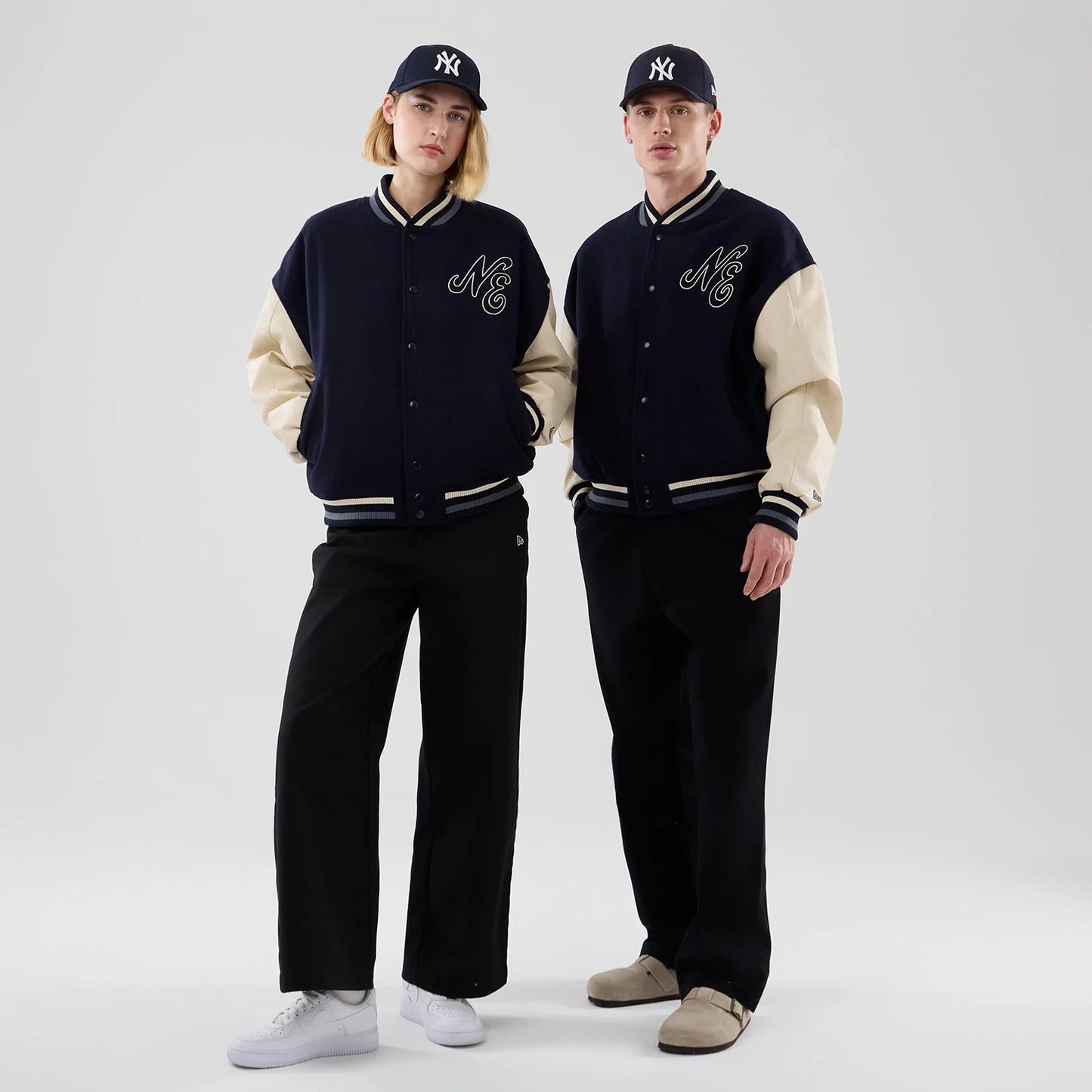 The model is wearing this New Era Oversized Varsity Jacket in navy. 1