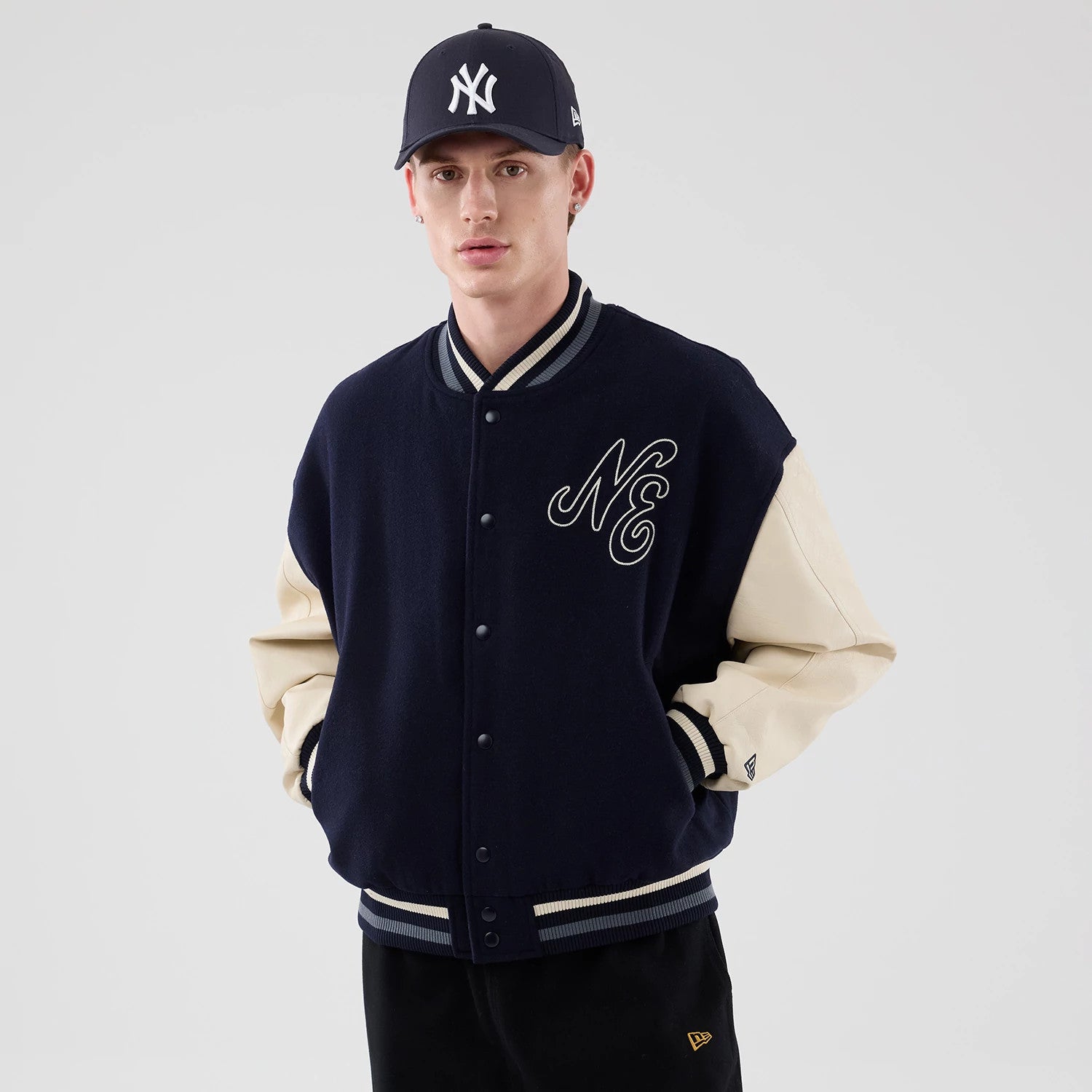 The model is wearing this New Era Oversized Varsity Jacket in navy. 3