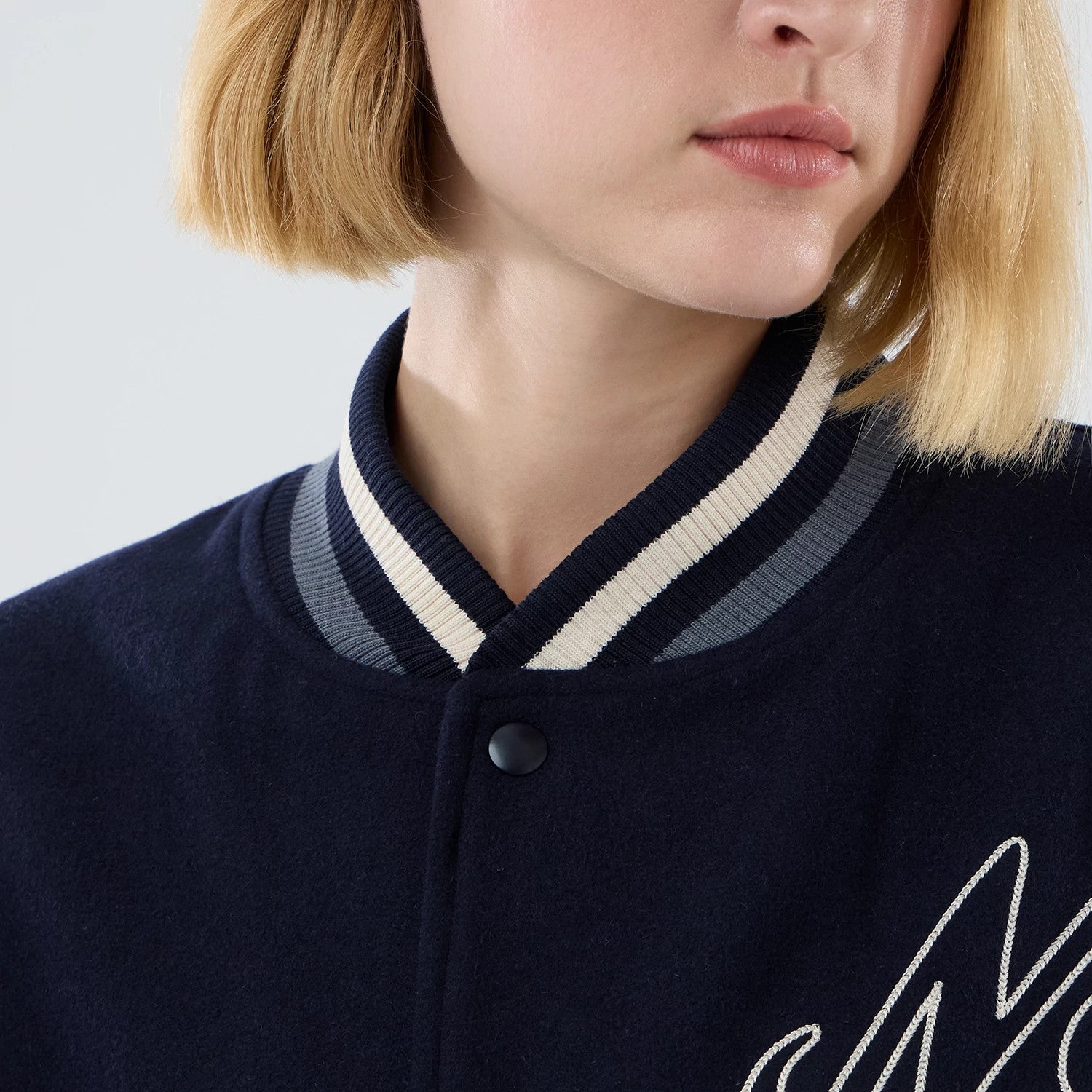 The model is wearing this New Era Oversized Varsity Jacket in navy. 6