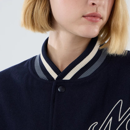 The model is wearing this New Era Oversized Varsity Jacket in navy. 6