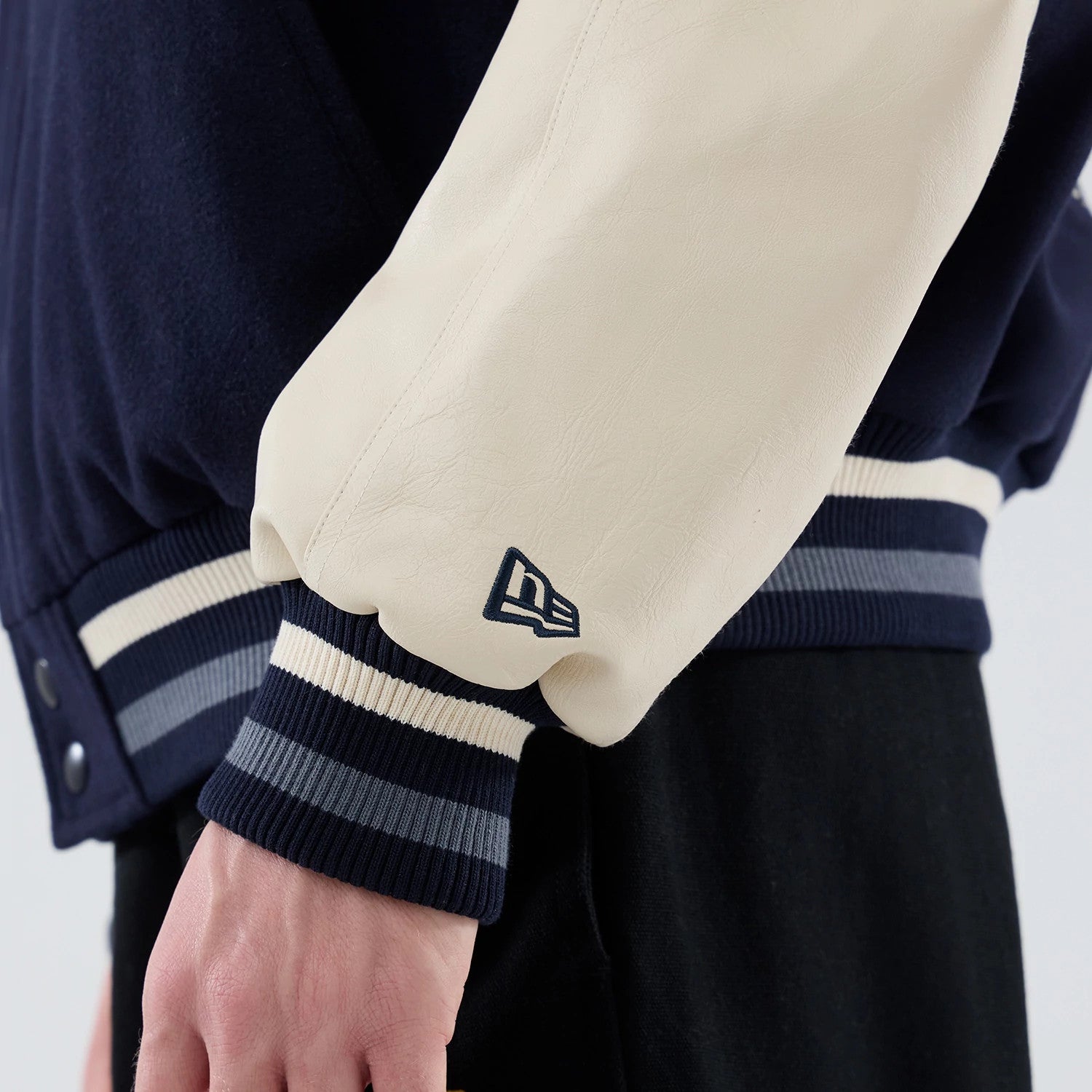 The model is wearing this New Era Oversized Varsity Jacket in navy. 7