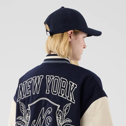 The model is wearing this New Era Oversized Varsity Jacket in navy. 8