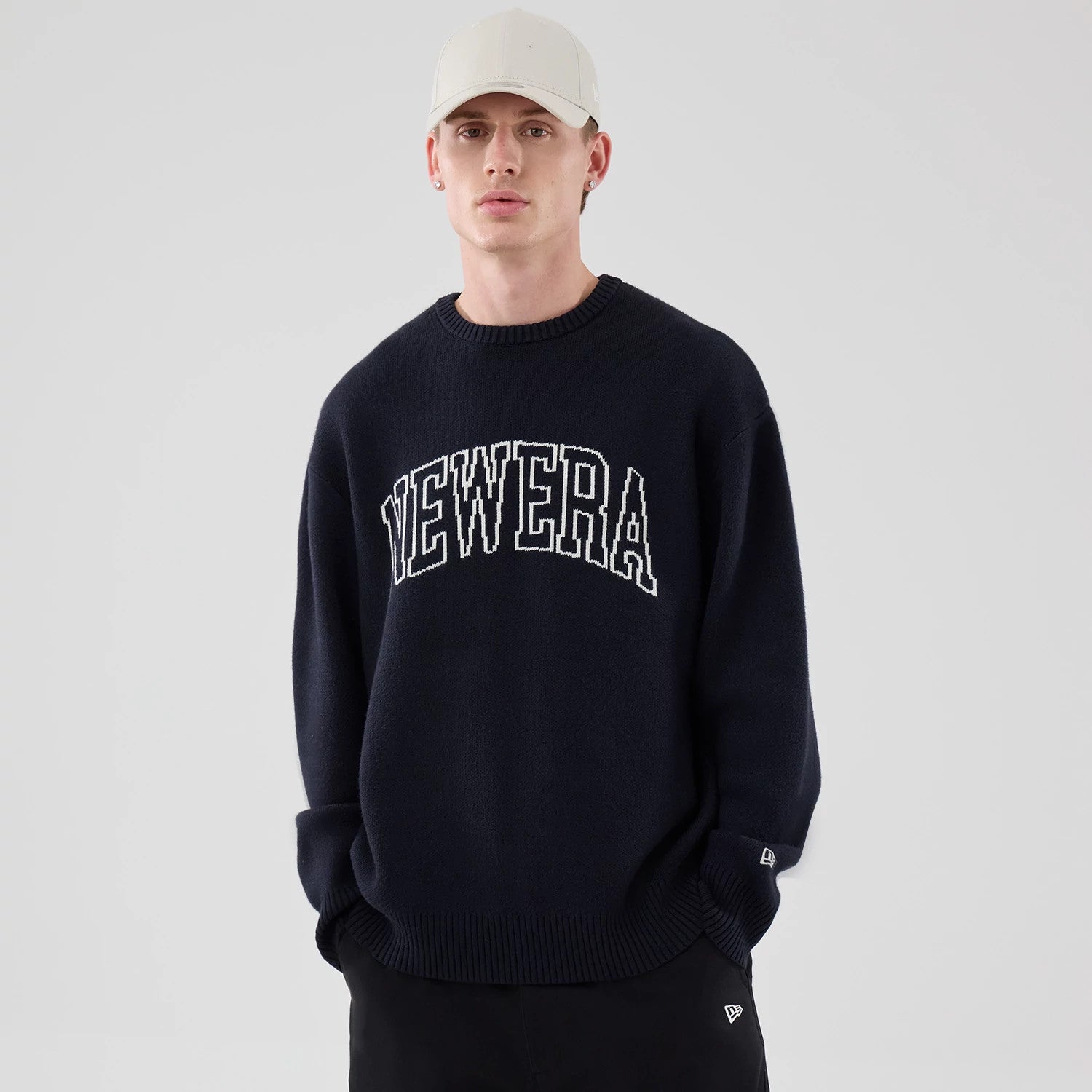 The model is wearing this New Era Knit Script Knitted Sweater in navy. 3
