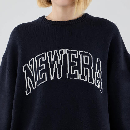 The model is wearing this New Era Knit Script Knitted Sweater in navy. 6