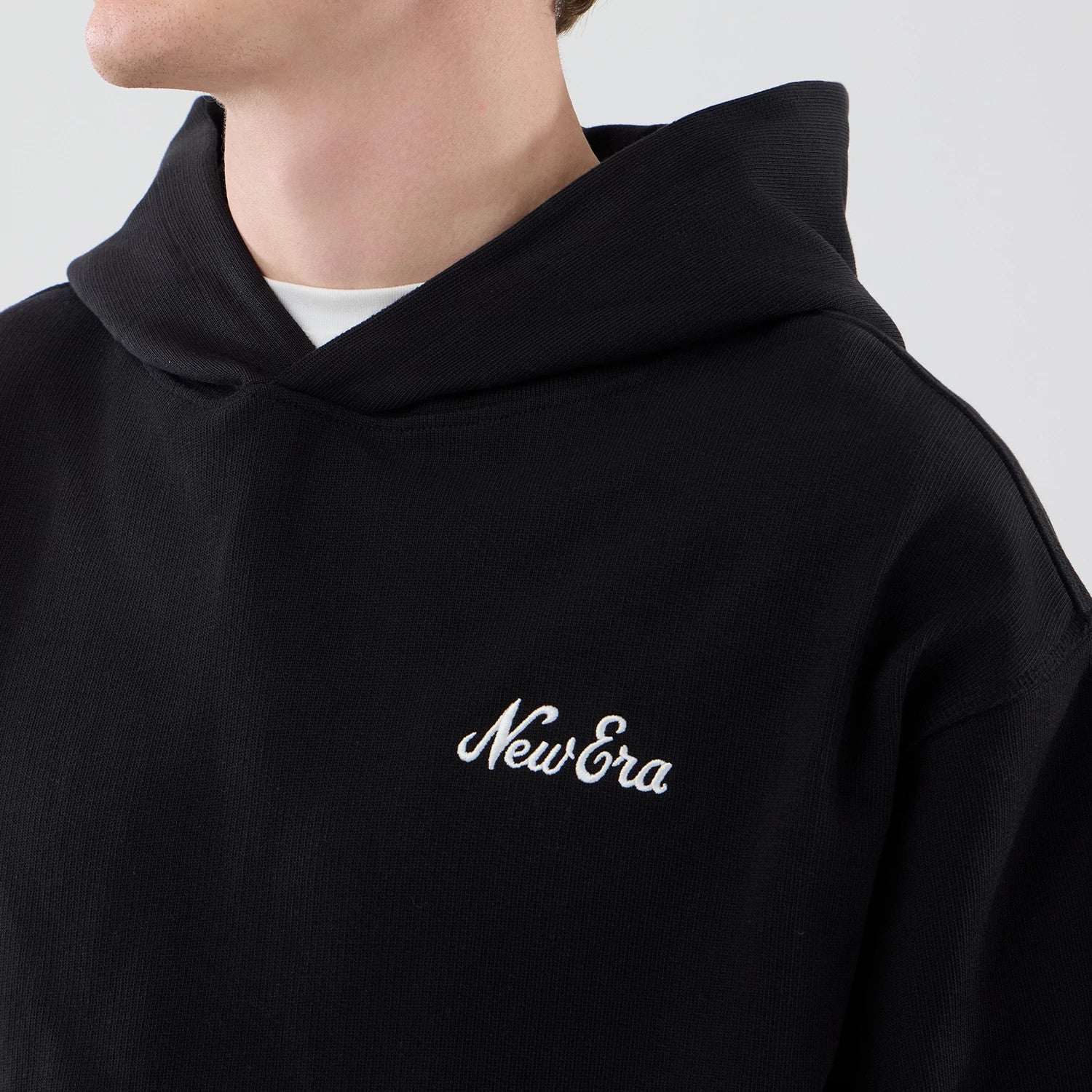 The model is wearing this New Era Open Hem Pullover Hoodie in black. 4