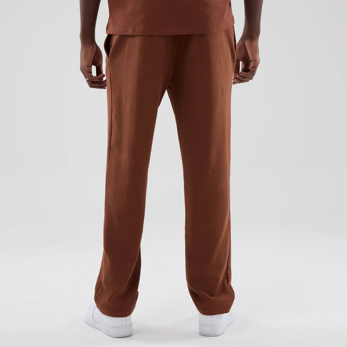 New Era Chicago Bulls NBA Core Plus Brown Straight Leg Joggers, rear view on a model showing the full straight leg design and relaxed fit, with two side pockets and an elasticated waistband, paired with white casual trainers.