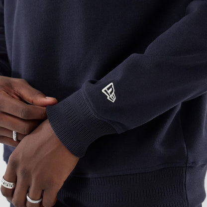 New Era LA Dodgers MLB Navy Oversized 1/4 Zip Sweater, close-up view showing the navy ribbed cuff with a white embroidered New Era flag logo, worn on a model's arm, highlighting the navy fabric texture and relaxed fit.