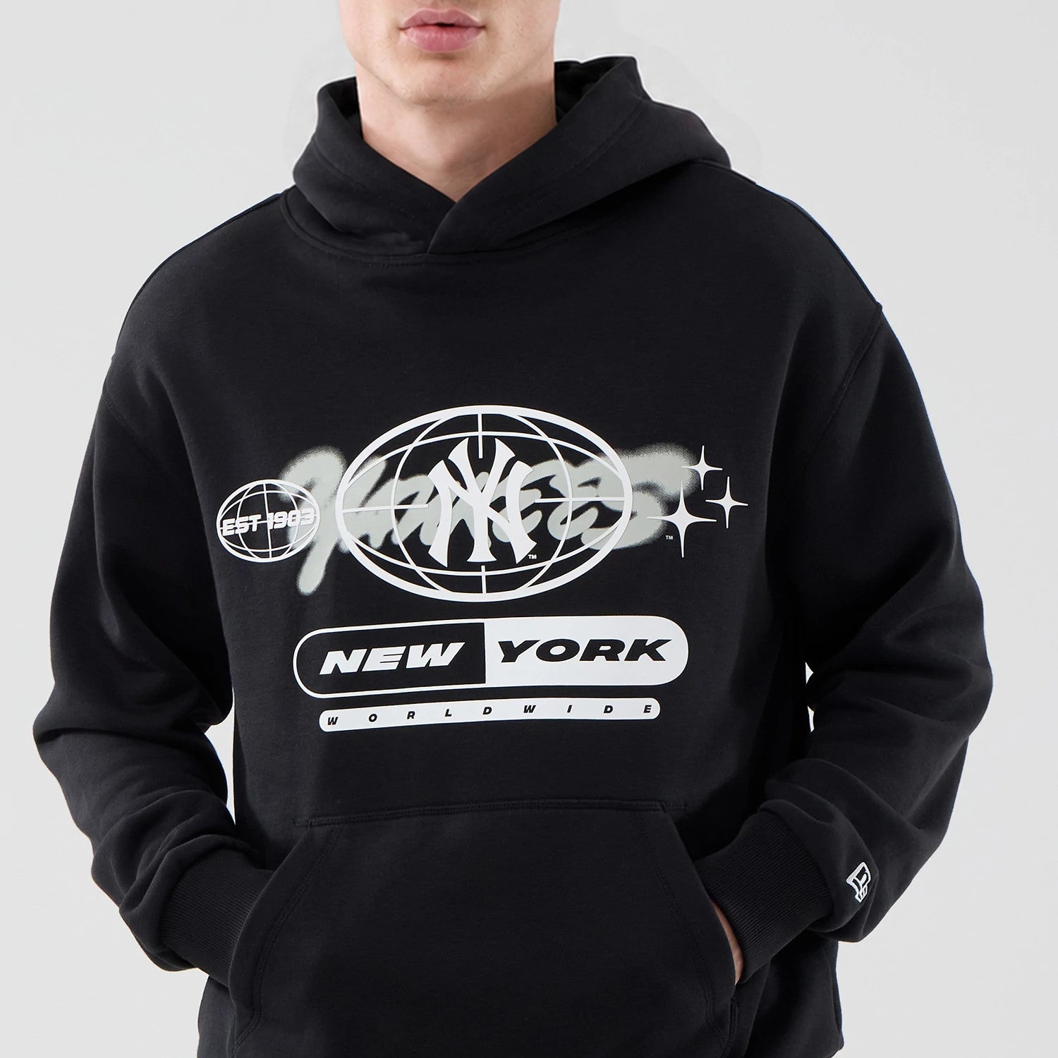 The model is wearing this MLB Logo Graphic New York Yankees Oversized Pullover Hoodie in black. 3