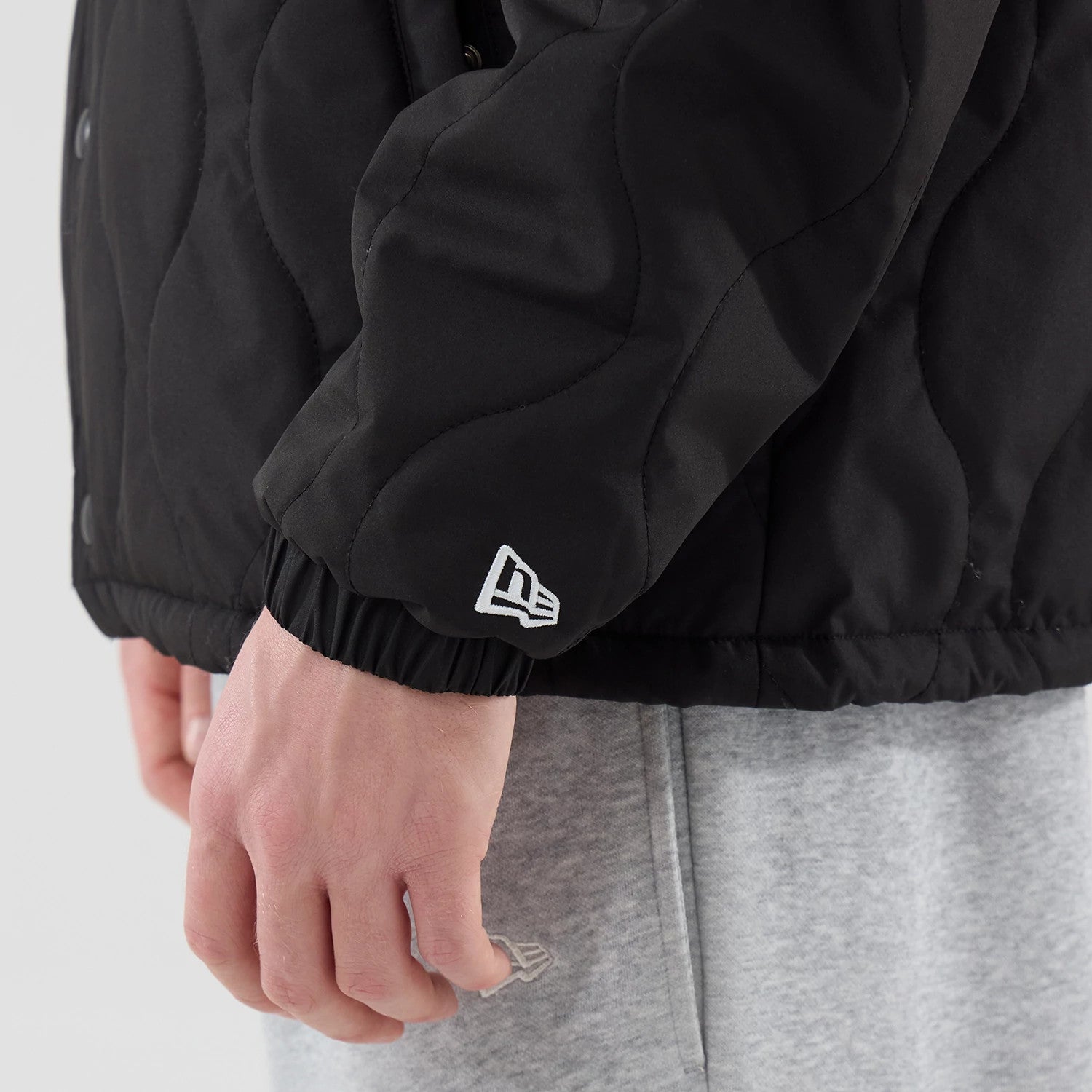 The model is wearing this New Era Quilted Coaches Jacket in black. 5