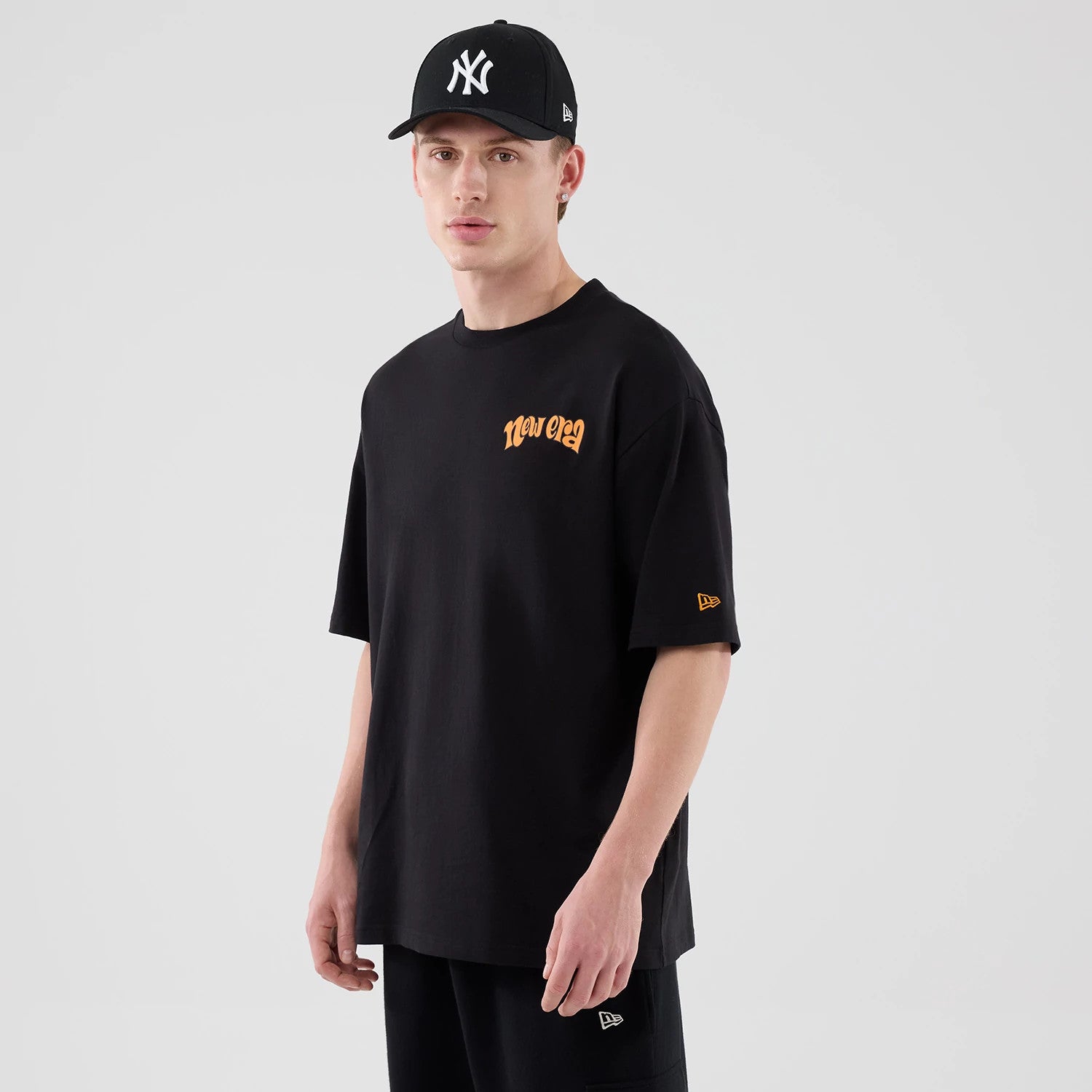 The model is wearing this New Era Hot Dog Graphic Oversized T-Shirt in black. 3