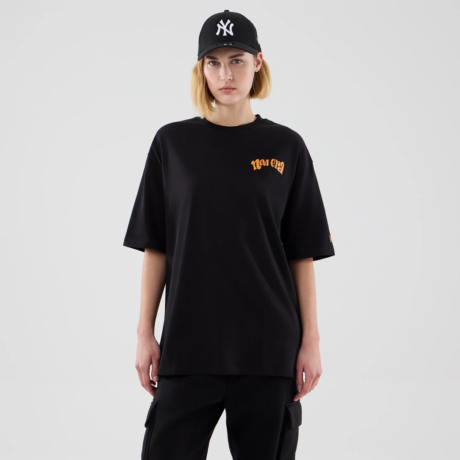 The model is wearing this New Era Hot Dog Graphic Oversized T-Shirt in black. 4