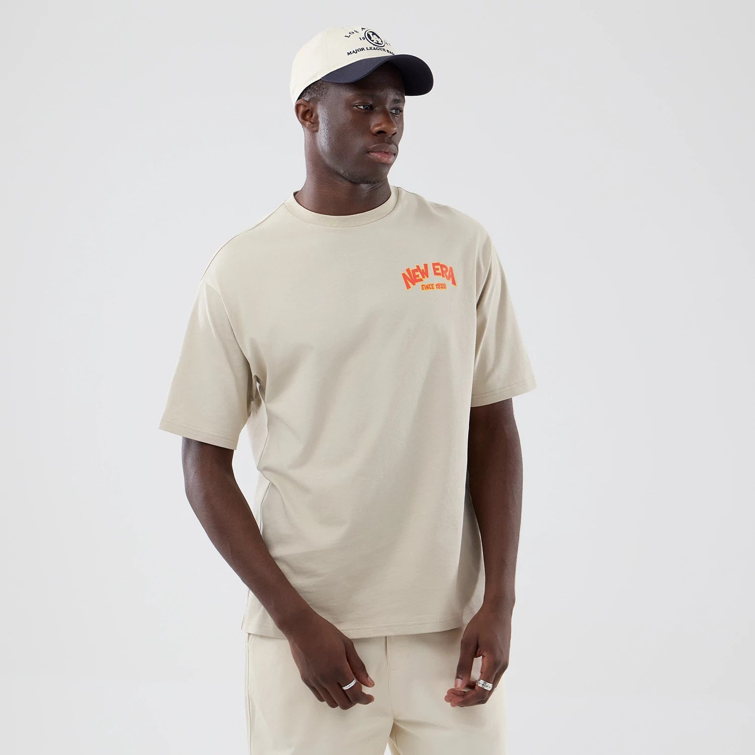 The model is wearing this New Era Food Graphic Oversized T-Shirt in light beige. 3