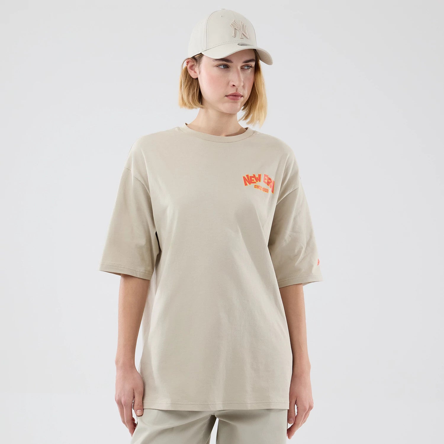 The model is wearing this New Era Food Graphic Oversized T-Shirt in light beige. 4