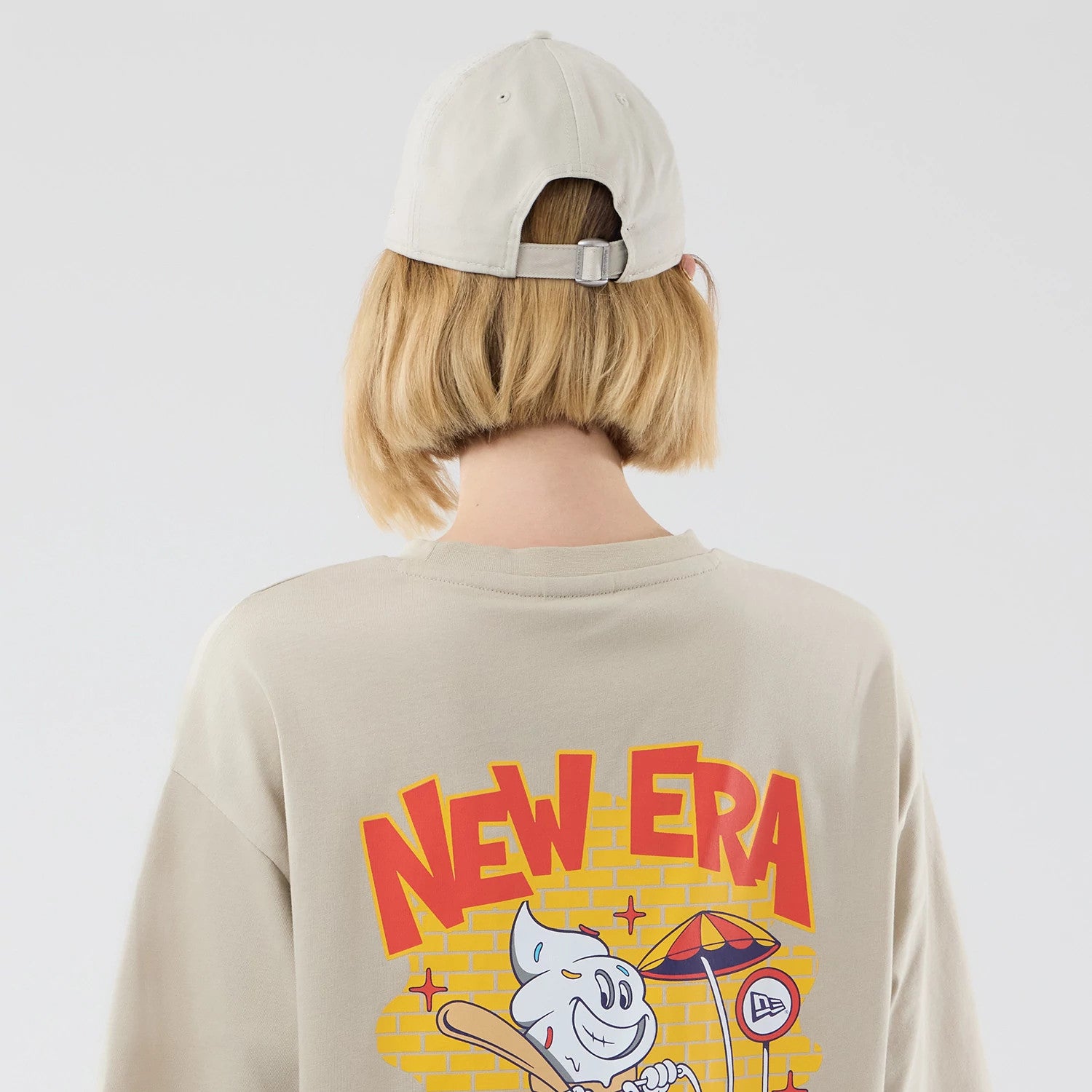 The model is wearing this New Era Food Graphic Oversized T-Shirt in light beige. 8