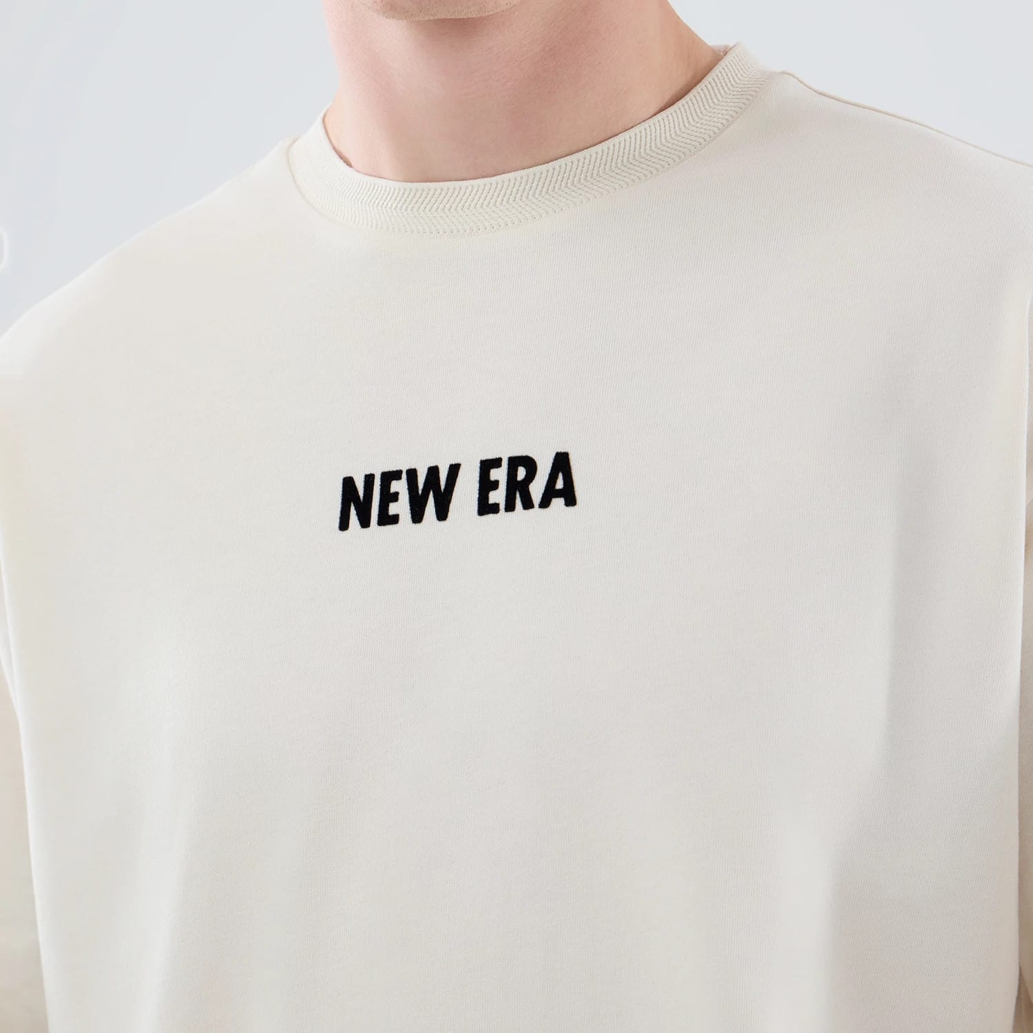 The model is wearing this New Era Cap Graphic Oversized T-Shirt in cream. 5