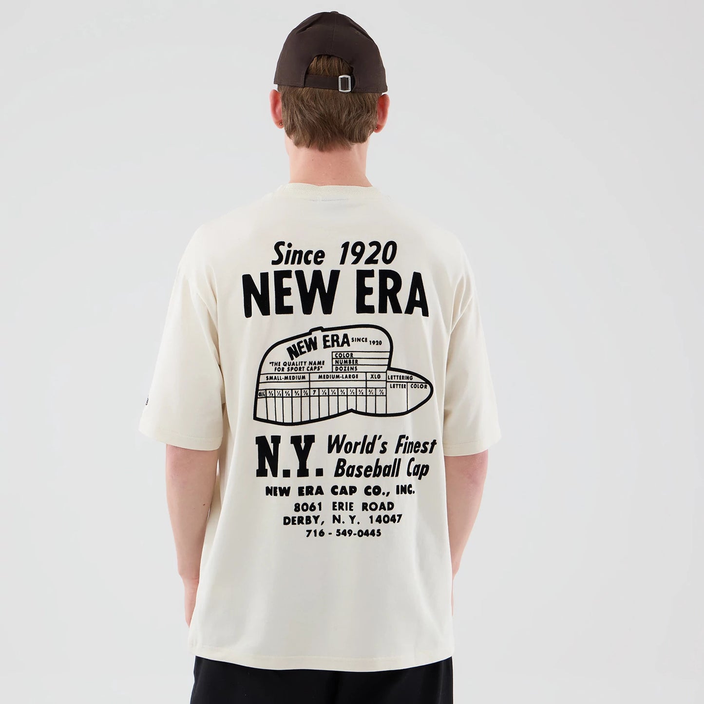 The model is wearing this New Era Cap Graphic Oversized T-Shirt in cream. 2