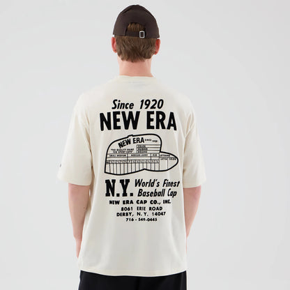 The model is wearing this New Era Cap Graphic Oversized T-Shirt in cream. 2