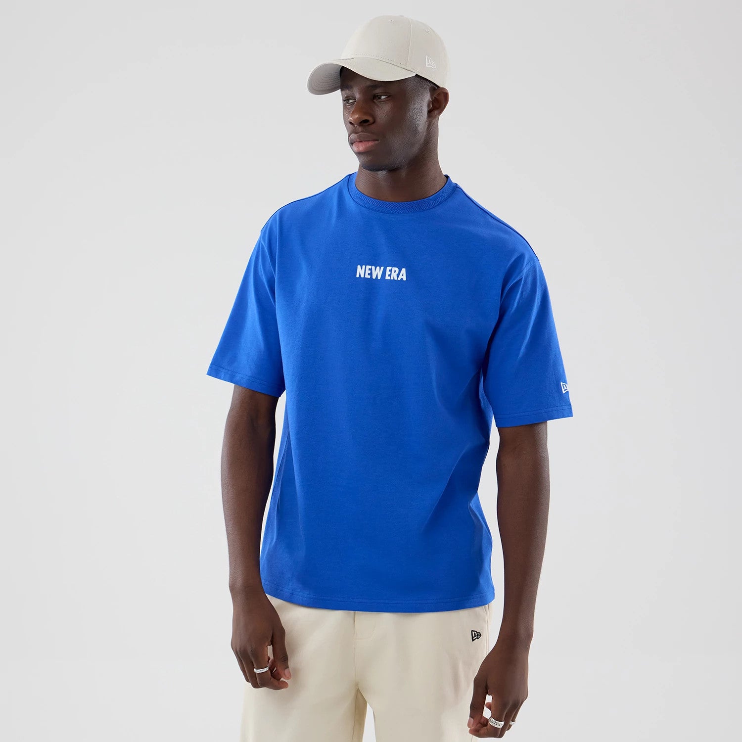 The model is wearing this New Era Cap Graphic Oversized T-Shirt in bright blue. 3