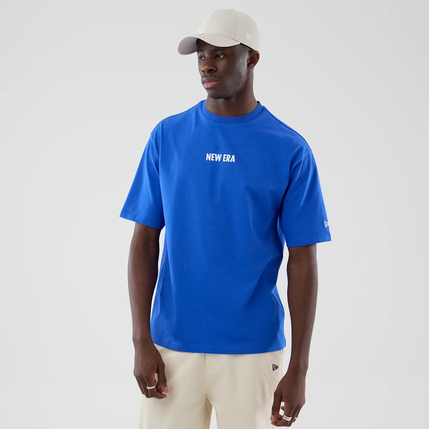 The model is wearing this New Era Cap Graphic Oversized T-Shirt in bright blue. 3