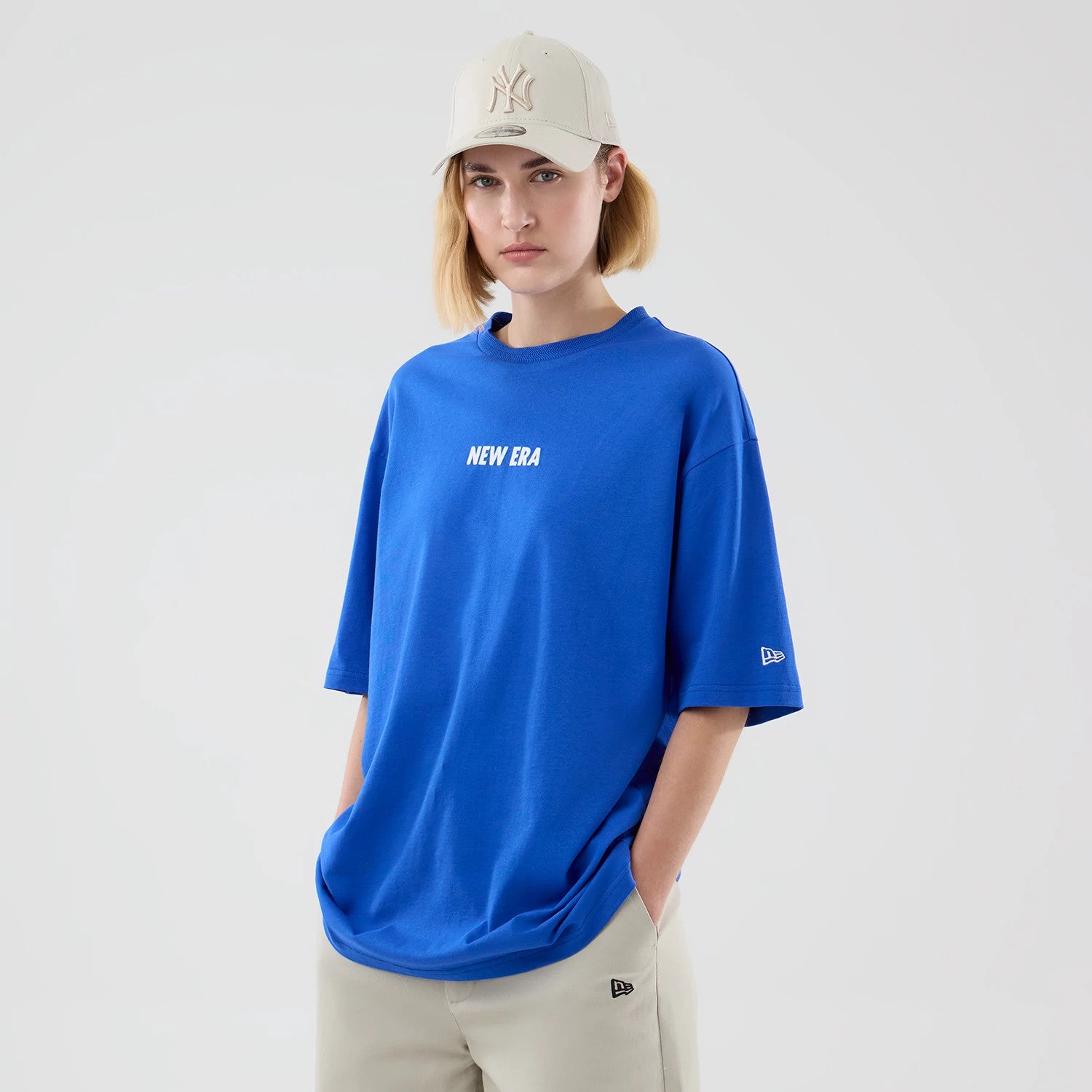 The model is wearing this New Era Cap Graphic Oversized T-Shirt in bright blue. 4