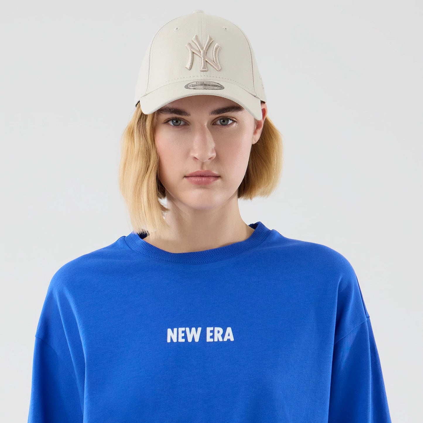 The model is wearing this New Era Cap Graphic Oversized T-Shirt in bright blue. 6