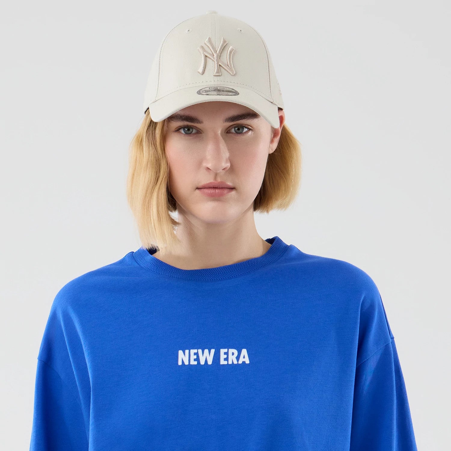 The model is wearing this New Era Cap Graphic Oversized T-Shirt in bright blue. 6