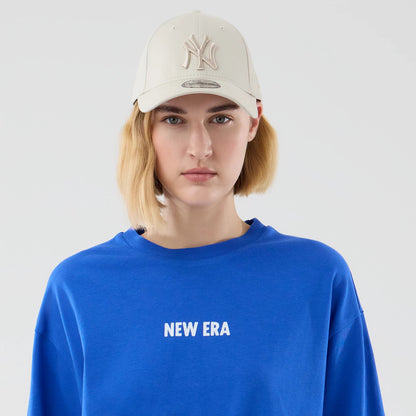 The model is wearing this New Era Cap Graphic Oversized T-Shirt in bright blue. 6