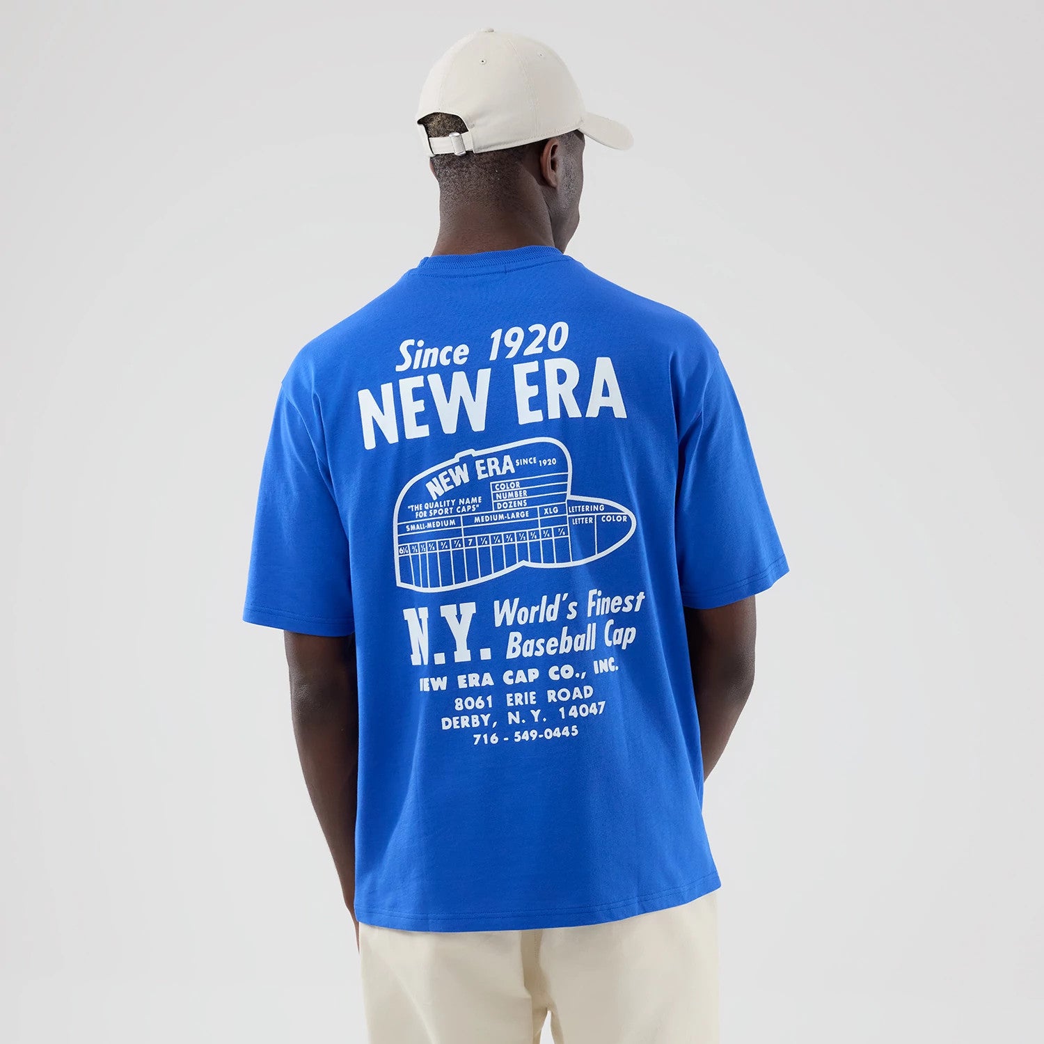 The model is wearing this New Era Cap Graphic Oversized T-Shirt in bright blue. 2