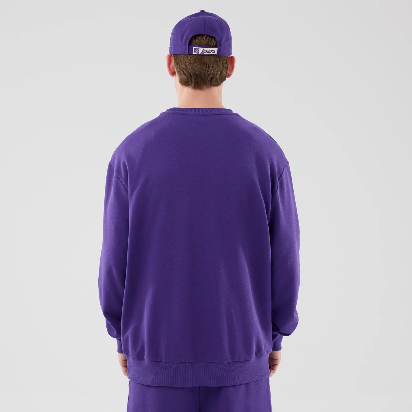 The model is wearing this NBA League Essential LA Lakers Oversized Crew Neck Sweater in purple. 2