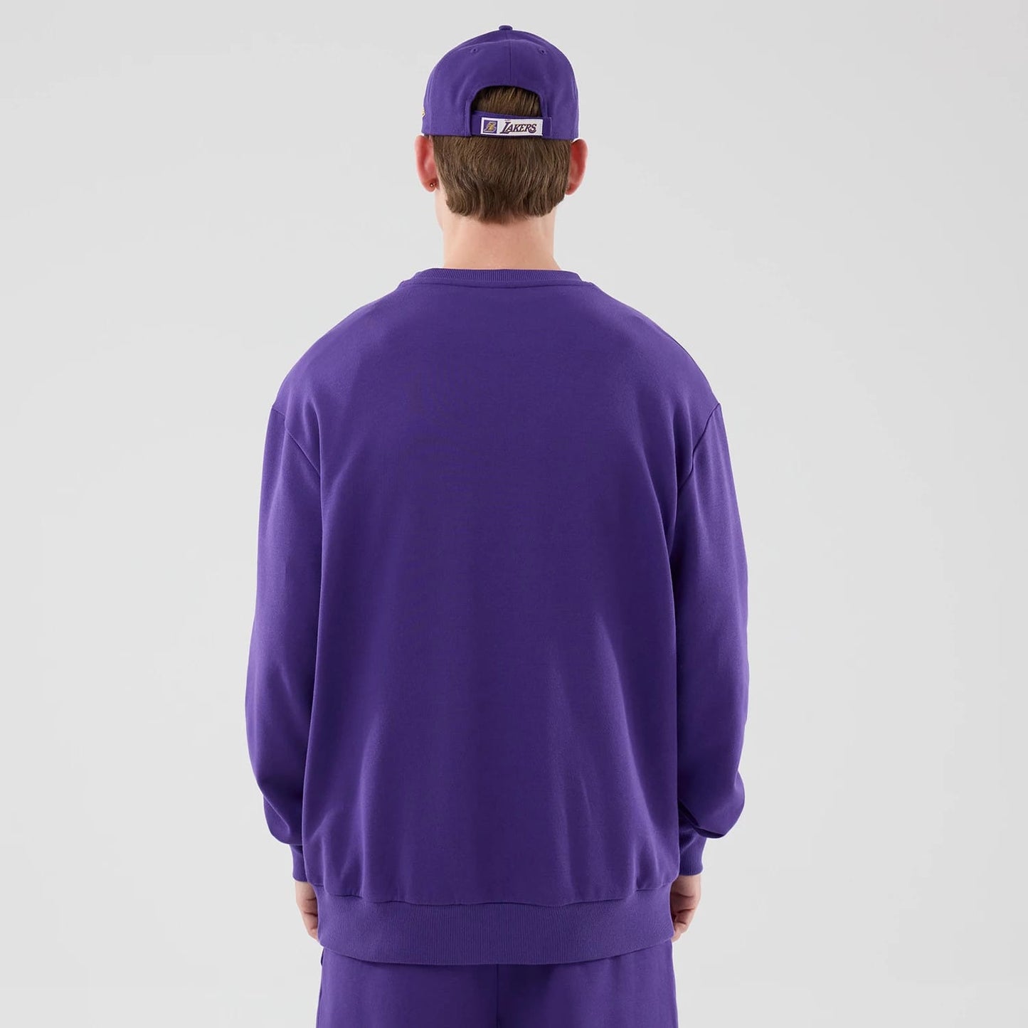 The model is wearing this NBA League Essential LA Lakers Oversized Crew Neck Sweater in purple. 2