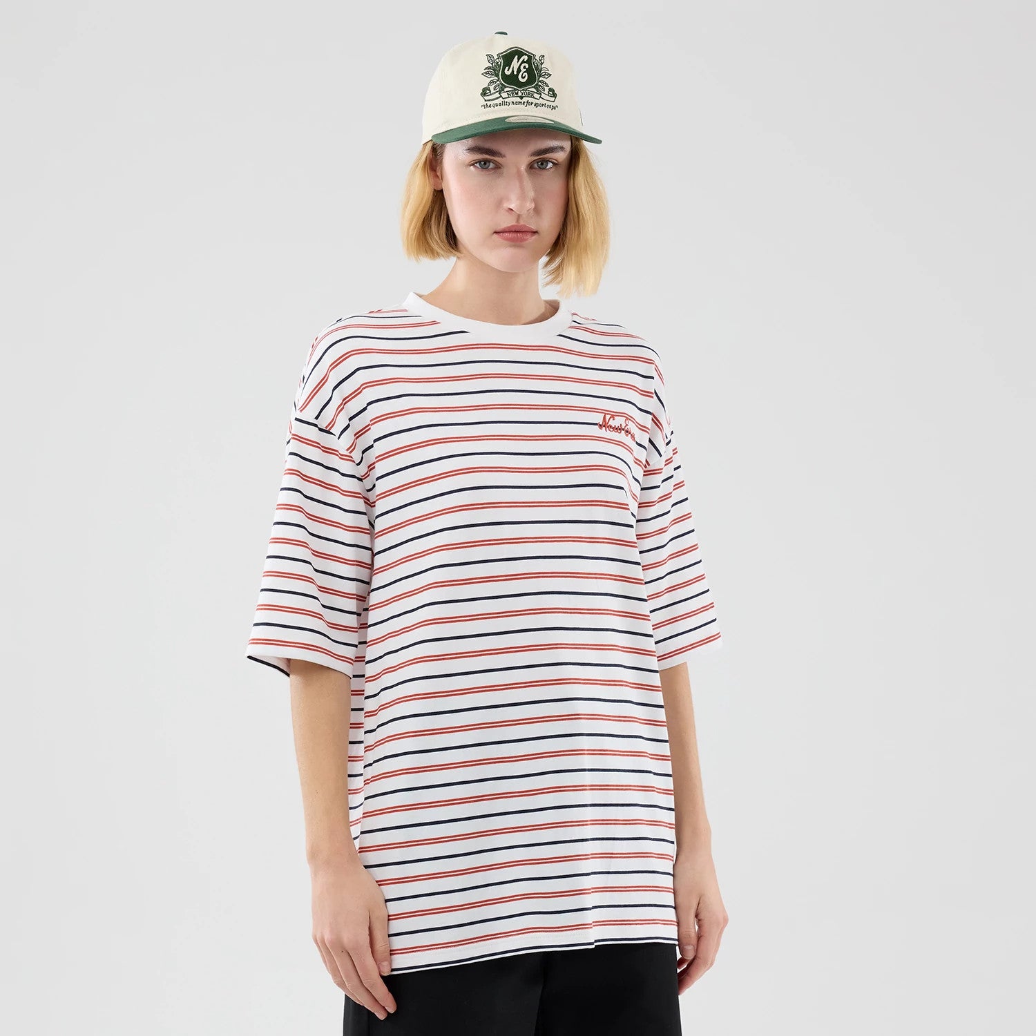 The model is wearing this New Era Stripe Oversized T-Shirt in white. 4