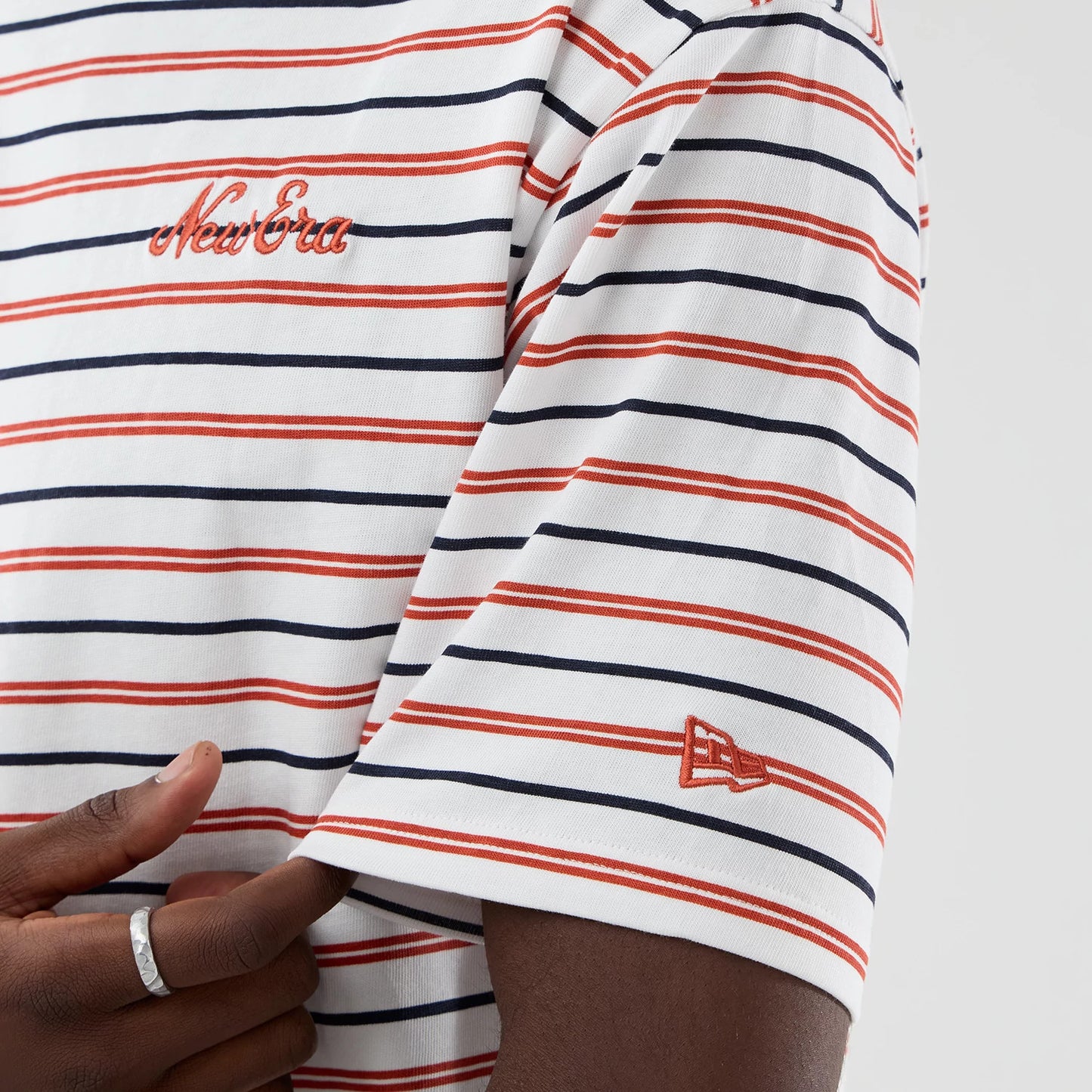 The model is wearing this New Era Stripe Oversized T-Shirt in white. 7