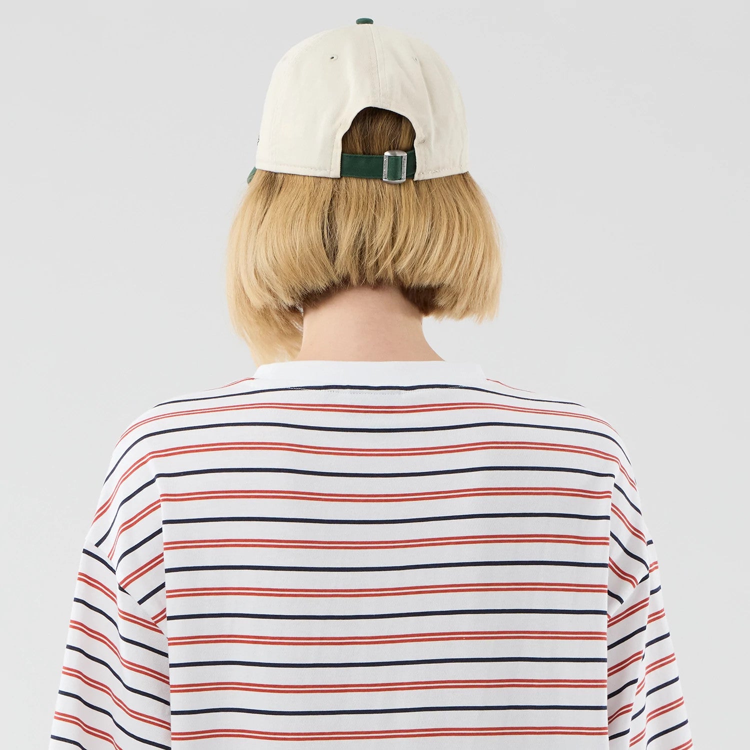 The model is wearing this New Era Stripe Oversized T-Shirt in white. 8