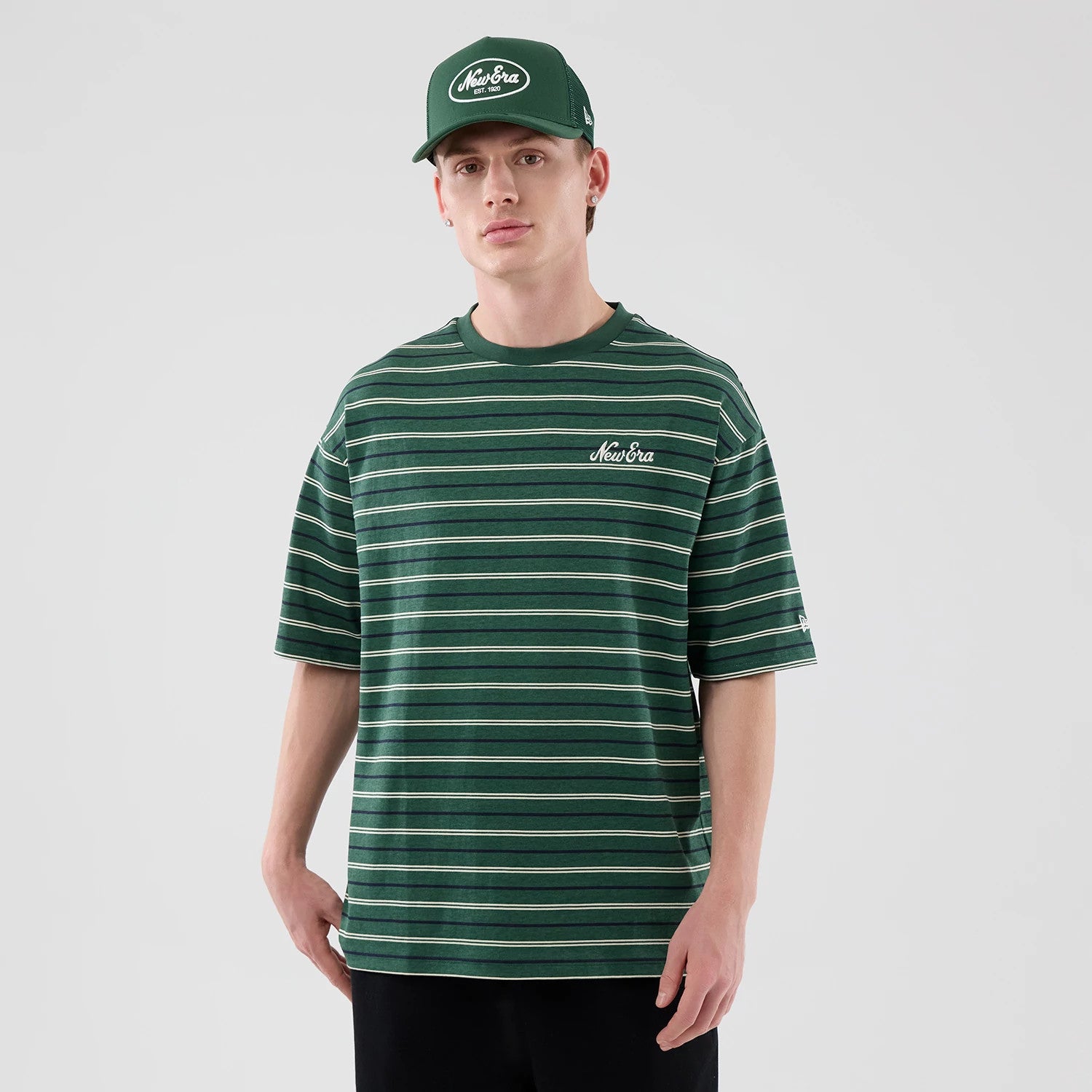 The model is wearing this New Era Stripe Oversized T-Shirt in dark green. 3